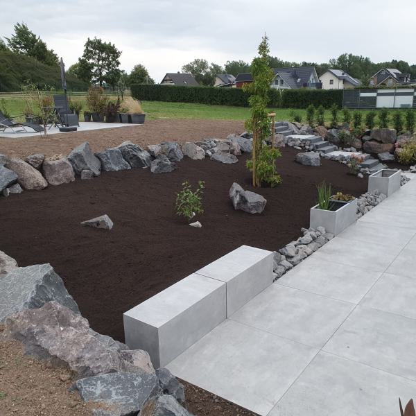 Außenbereich mit großer Betonterrasse, Pflanzgefäßen