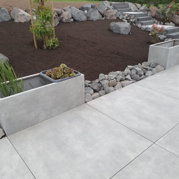 Außenbereich mit großer Betonterrasse, Pflanzgefäßen