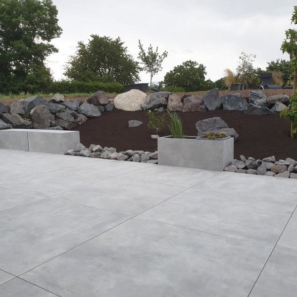 Außenbereich mit großen Wegplatten und Betonbänke
