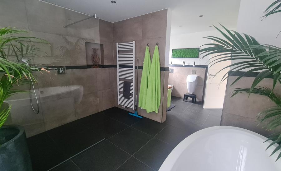 Modernes dunkel abgesetztes Badezimmer mit freistehender Badewanne