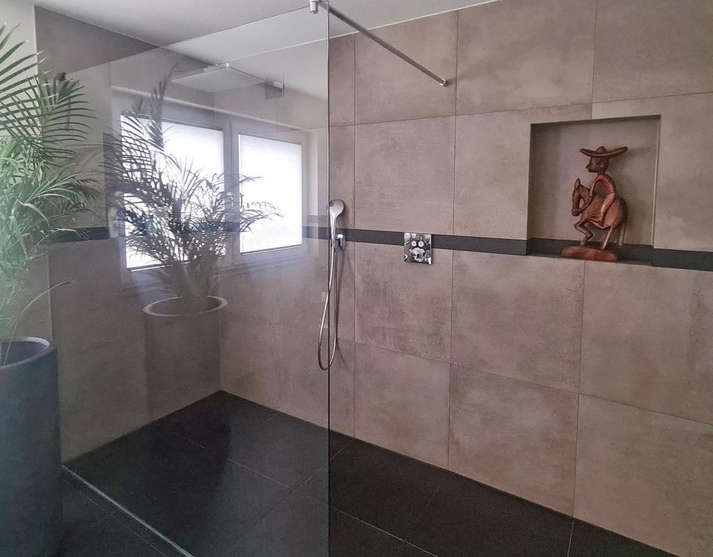 Atmosphärische dunkel geflieste Dusche