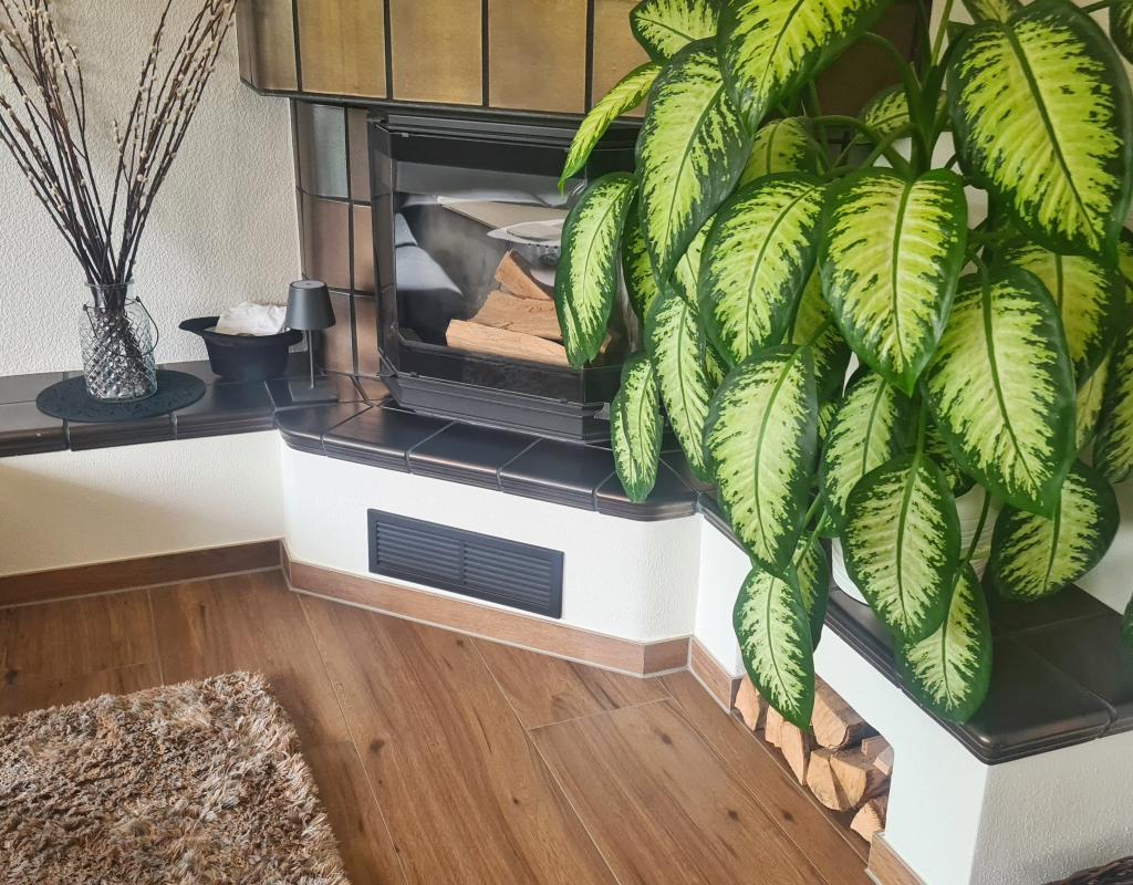 Wohnzimmer mit Kamin und Begrünung